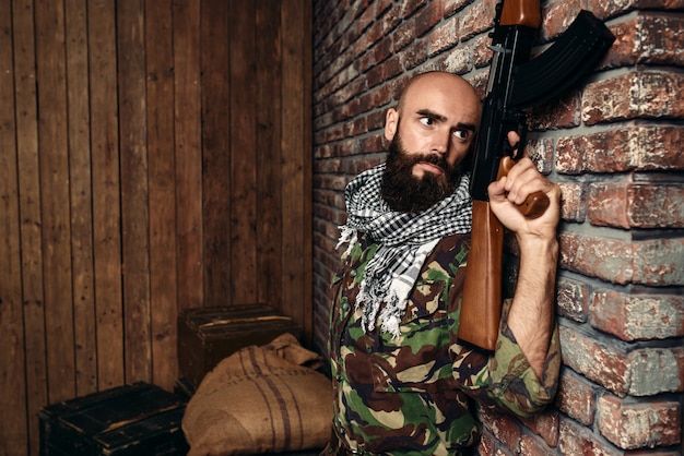 Terrorist with rifle hiding behind a wall