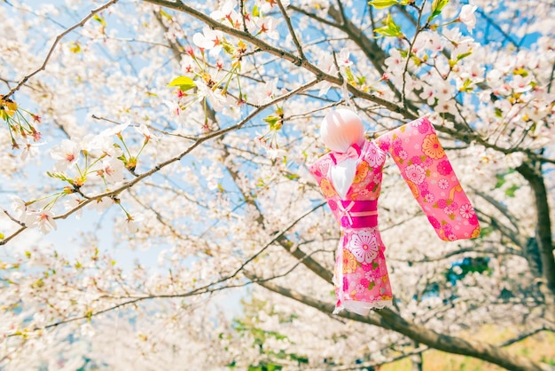 Foto teru teru bozu. bambola giapponese della pioggia appesa all'albero di sakura per pregare per il bel tempo