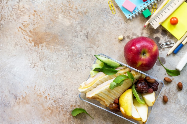 Terug naar school achtergrond met schoolbenodigdheden lunchbox en appel Bovenaanzicht plat lag kopieerruimte