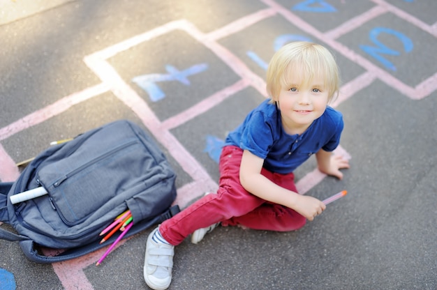 Terug naar school-concept. Kleine jongen op schoolplein