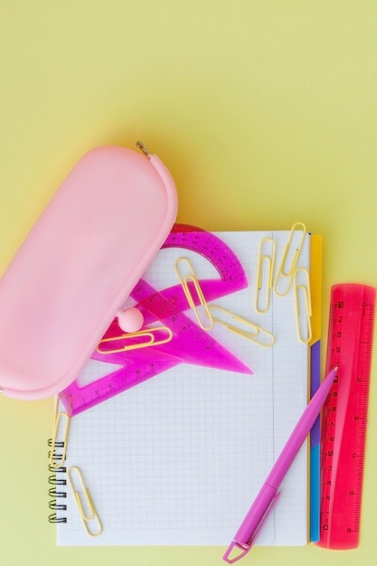 Terug naar school concept met ruimte voor tekst Bovenaanzicht kopie ruimte School kantoorbenodigdhedenCreatief bureau met kleurrijke briefpapier Gekleurde paperclipSchoolbenodigdheden op gele achtergrondBureau