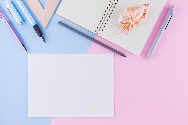 Terug naar school concept School briefpapier en schelp op roze blauwe achtergrond Potloden potlood en gon