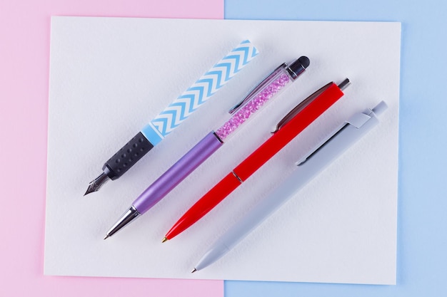 Terug naar school concept School briefpapier op roze blauwe achtergrond Meerkleurige pennen