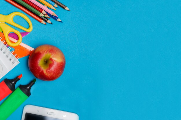 Terug naar school concept - school kantoorbenodigdheden op blauw papier