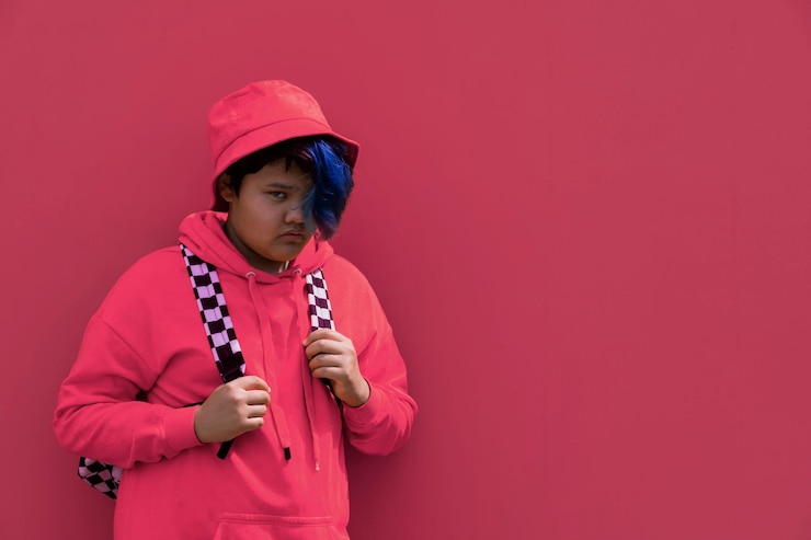 Foto terug naar school een tienermeisje met blauw haar in roze hoodie panama hoed met rugzak middelbare school