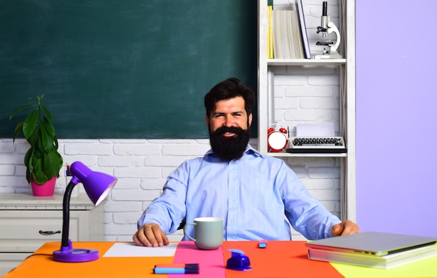 Terug naar school en gelukkige tijd bebaarde professor in de klas op schoolbord achtergrond kennisdag