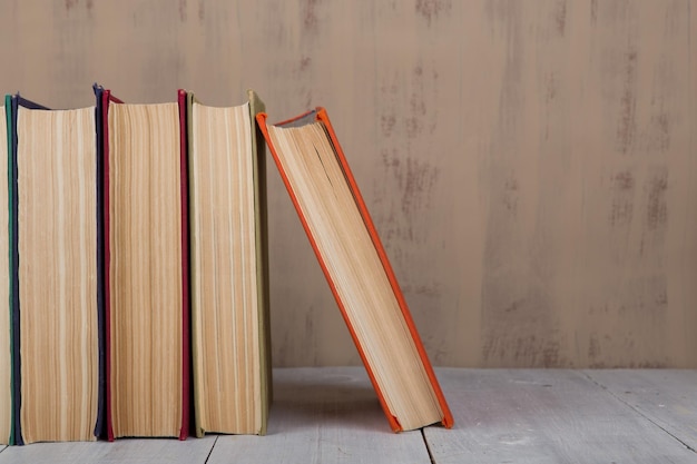 Terug naar school en onderwijsconcept stapel kleurrijke boeken met harde kaft op witte houten tafel