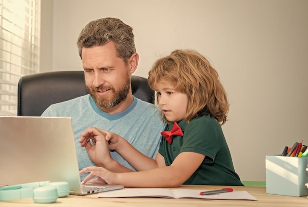 Terug naar school gebruiken vader en zoon de computer thuis voor familie- en ouderschapsblog