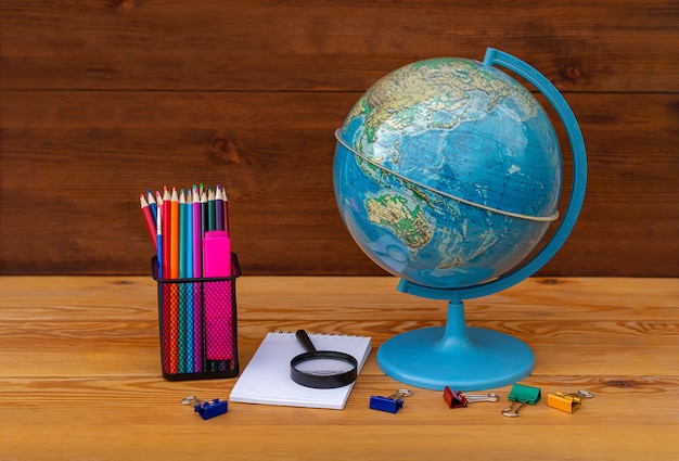 Foto terug naar school! globe, earth-model, educatief materiaal op een houten tafel op een globe van azië en australië.