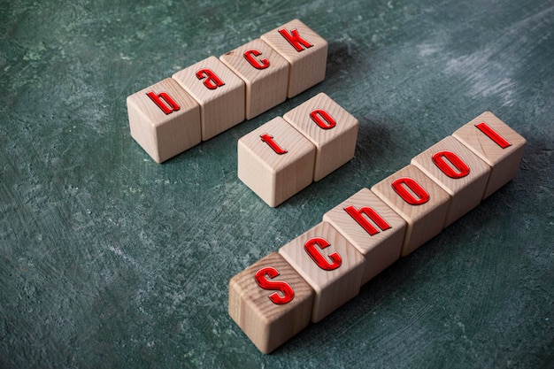 Foto terug naar school inscriptie op houten kubussen op de achtergrond van een groen schoolbord