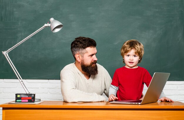 Terug naar school Jong volwassen concept Papa en zijn zoontje Basisschoolkind en leraar in de klas op school Terug naar school en onderwijsconcept