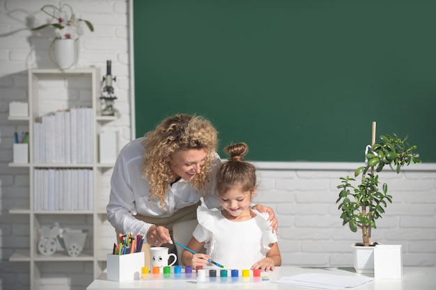 Terug naar school kind tekenen met leraar kinderen van de basisschool studeren bij tekenles leerling w