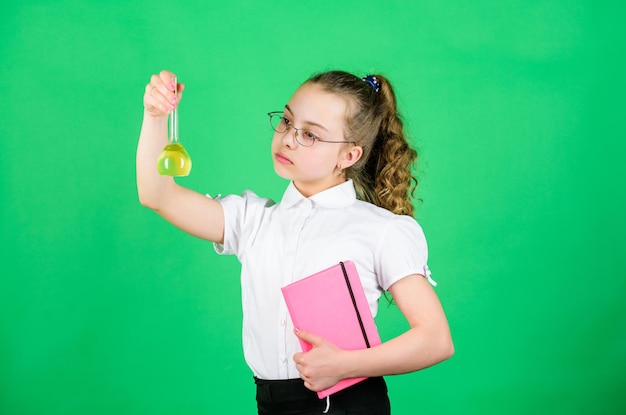 Terug naar school. kleine slimme meid met testfles. onderwijs en kennis. kind studie biologie les met notitie. wetenschappelijk onderzoek in het laboratorium. Klein schoolmeisje. Zelfverzekerde apotheker.