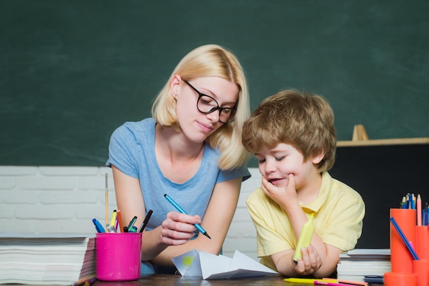 Terug naar school kleuterschool en kind concept moeder leert haar zoon in de klas op school