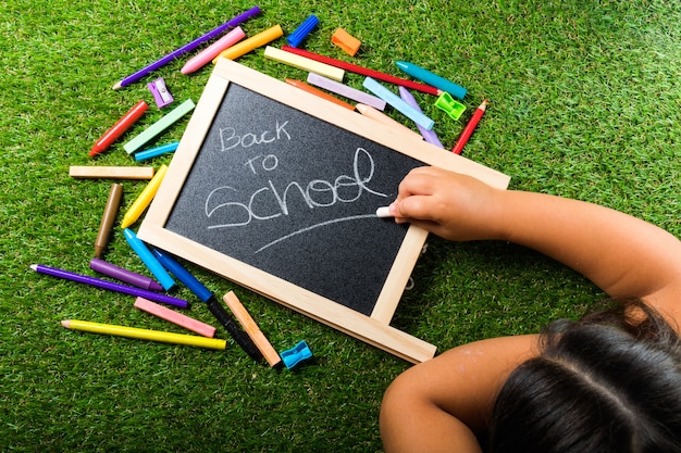 Terug naar school levert regeling levendige kleurrijke op groen gras en schoolbord hand krijt