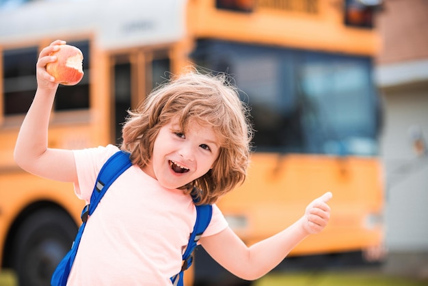 Terug naar school opgewonden schooljongen op schoolbus kind met positief gebaar met hand duimen omhoog glimlachend...