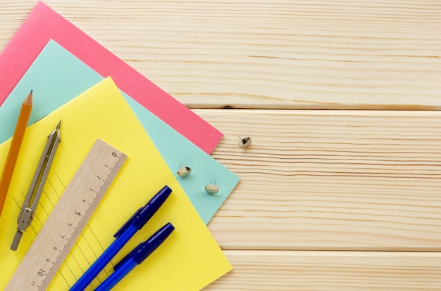 Terug naar school plat. Briefpapier op een lichte houten achtergrond, bovenaanzicht