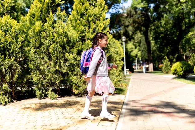 Terug naar school Schattig kind meisje met rugzak rennen en naar school gaan met plezier