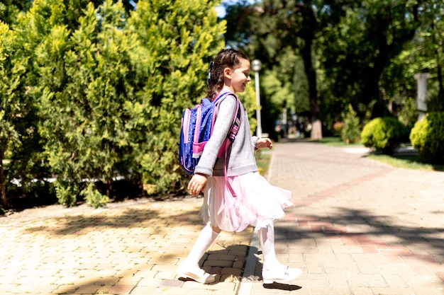 Terug naar school Schattig kind meisje met rugzak rennen en naar school gaan met plezier