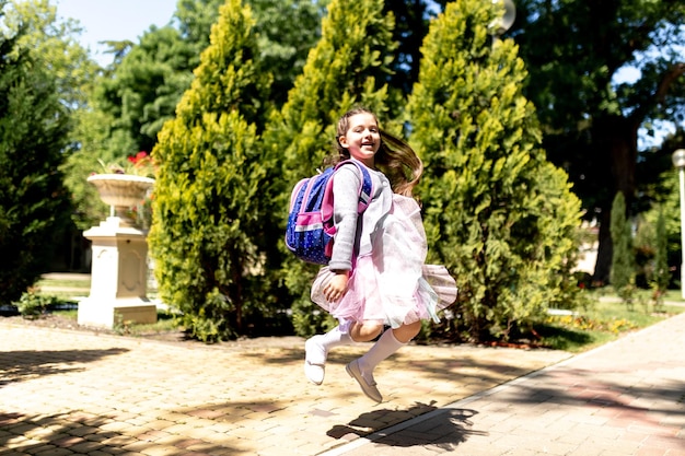 Terug naar school Schattig kind meisje met rugzak rennen en naar school gaan met plezier