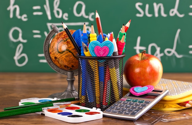 Terug naar school - schoolbord met pennenbak en schoolspullen op tafel