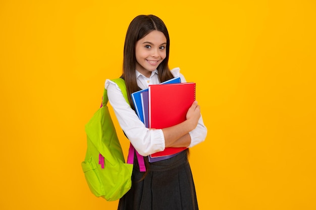 Terug naar school Schoolmeisje student met schooltas rugzak houden boek op geïsoleerde studio achtergrond School en onderwijs concept tiener meisje in schooluniform