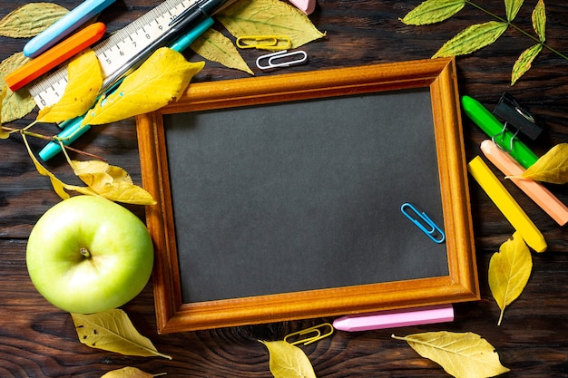 Terug naar school Tafel met herfstbladeren notitieblok appel en schoolspullen