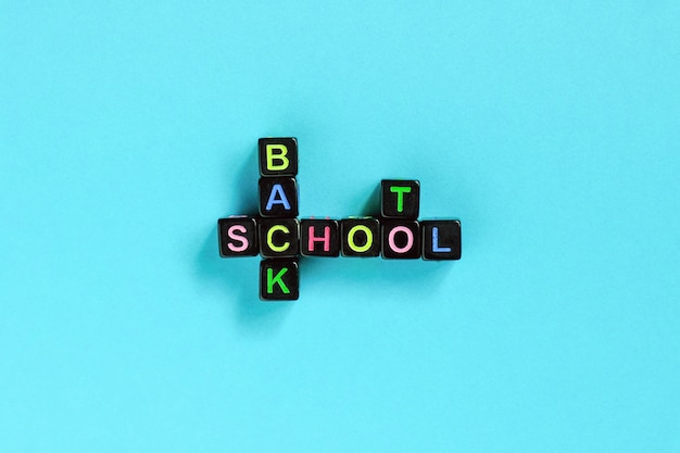 Terug naar school tekst van kleurrijke letters op zwarte blokjes opgemaakt in de vorm van een kruiswoordpuzzel