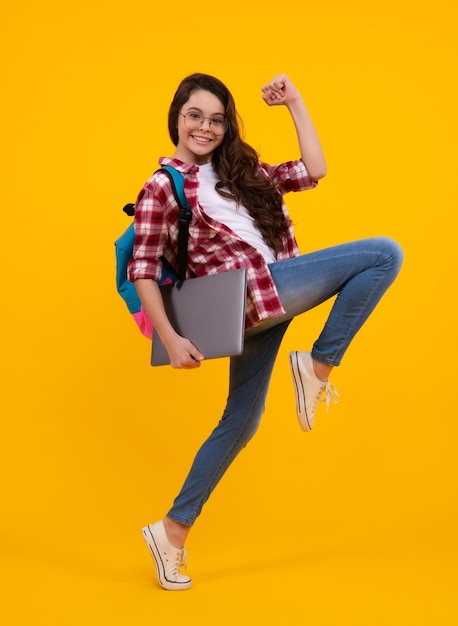 Terug naar school Tiener schoolmeisje houdt notebook laptop Schoolkinderen op geïsoleerde gele studio