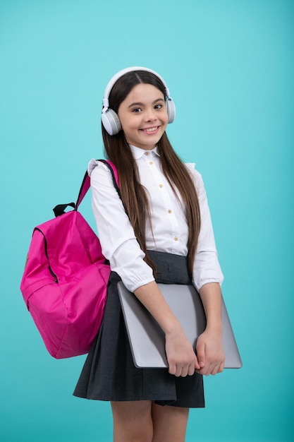 Terug naar school Tiener schoolmeisje in schooluniform met rugzak koptelefoon en laptop School