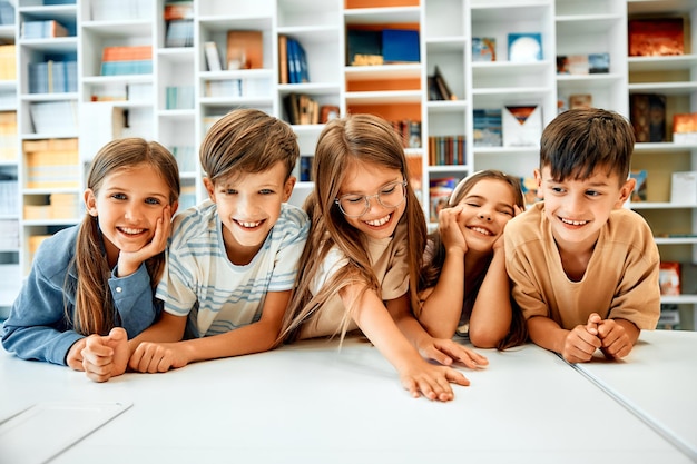 Terug naar school Vrolijke schoolkinderen zitten aan hun bureau tijdens een les tegen de achtergrond