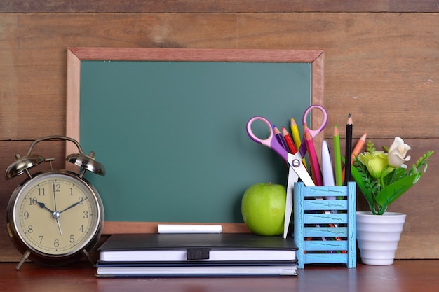 Terug naar schoolconcept met boeken en wekker met bord