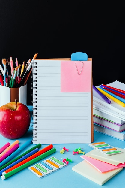 Terug op school, werk, werkplek van een schoolkind briefpapier, notebooks op blauw