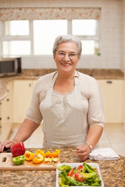 Teruggetrokken vrouw die de camera in de keuken bekijkt