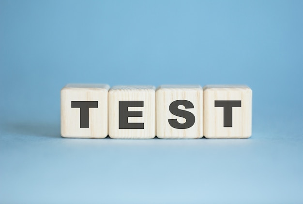 テスト。概念。木製の立方体で書かれた単語テスト。教育、医療、品質管理。