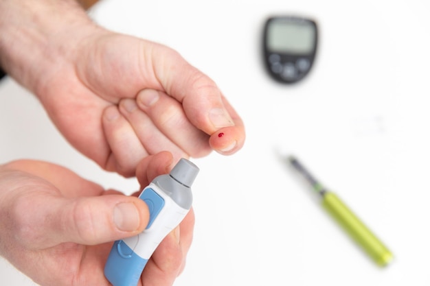 Test For Diabetes Man using lancet for diabetes checking blood sugar level