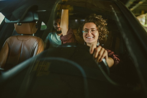 車を運転し、満足そうに見える縮れ毛の女性を試乗