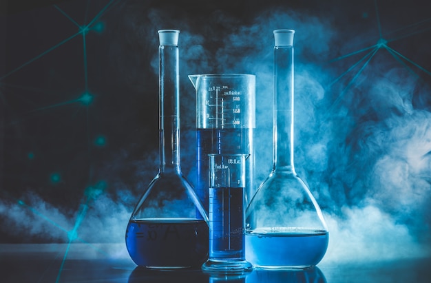 Test tube and flask with blue liquid and blue smoke. Chemistry and laboratory concept.