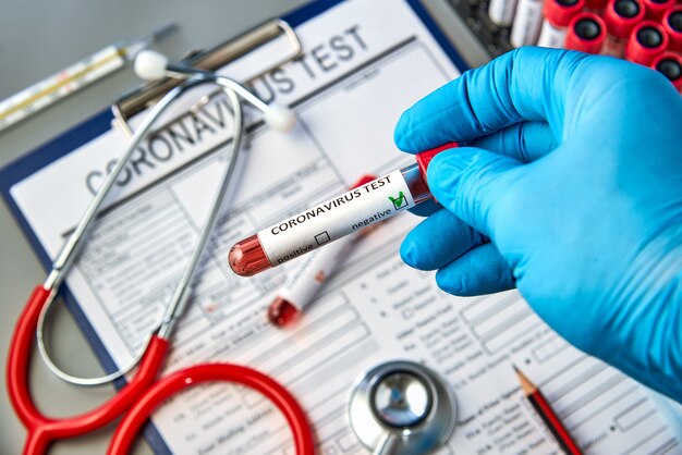 Photo test tube in hand with a negative blood test for covid-19