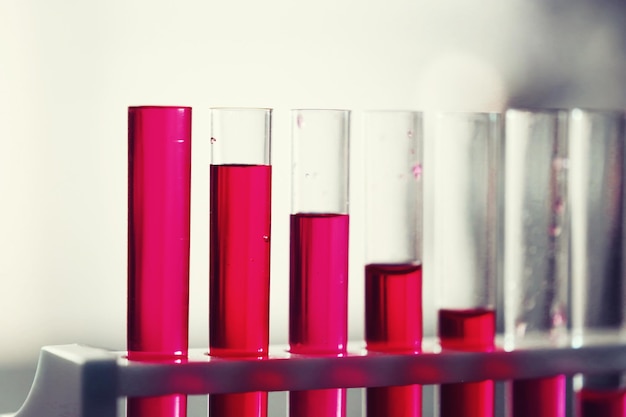 Test tube with blue liquid on laboratory table. Examination of liquid under a microscope.