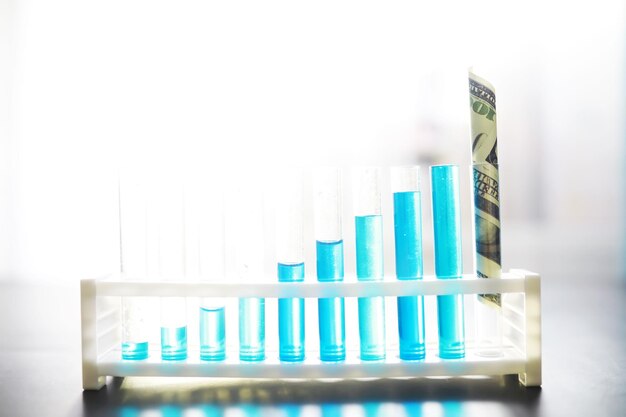 실험실 테이블에 파란색 액체가 있는 시험관 현미경으로 액체 검사