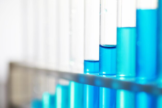 Test tube with blue liquid on the laboratory table Examination of liquid under a microscope