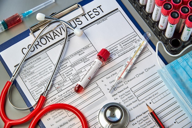 A test tube with a positive blood sample for the COVID-19 test on the coronavirus test form.  