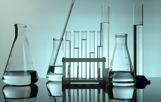 Test tubes and flasks stand with clear liquids on a table in a\
laboratory