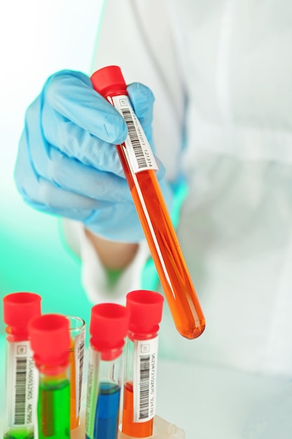 Test tubes with colorful liquid in scientist hand closeup