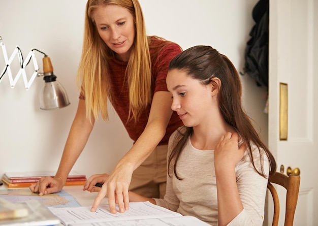 Testare i limiti della memoria di sua madre inquadratura di un'adolescente che riceve un aiuto per lo studio da sua madre