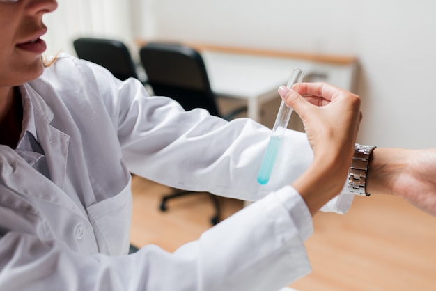 Testing the PH of a chemical in a test tube.