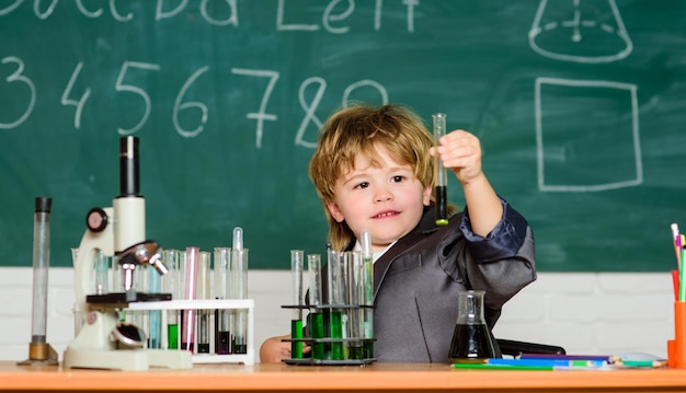 Provette con liquido per ricerca ragazzino studio risultato chimico concetto medico ragazzino bambino che usa il microscopio a scuola lezione imparare per il futuro studente fiducioso che studia