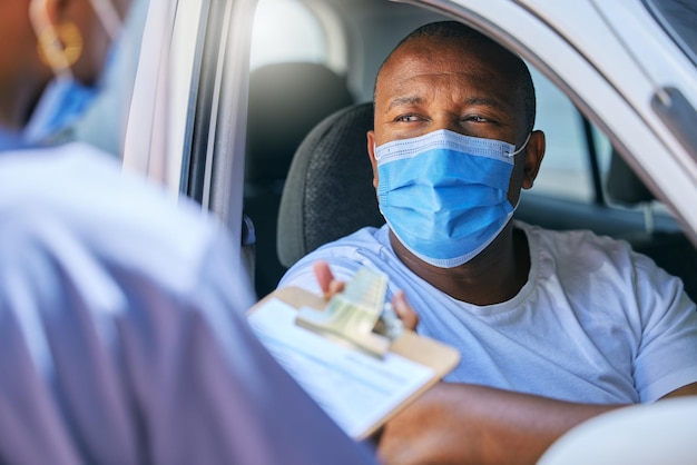 Testinterview en praten bij een controlepost tijdens covid-lockdown voor reizend vervoer en reizen Man met een masker om te beschermen, veilig te houden en ziekte te voorkomen tijdens het invullen van formulieren