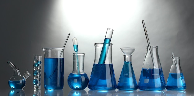 testtubes with blue liquid on grey background